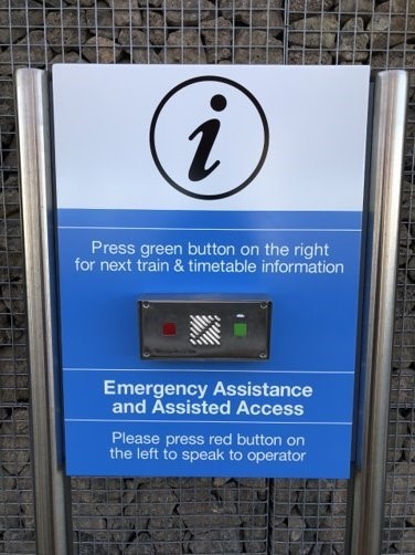 An image of the Customer Help Point signage and buttons. It reads “Press green button on the right for next train and timetable information.” And “Please press red button on the left to speak to operator.”